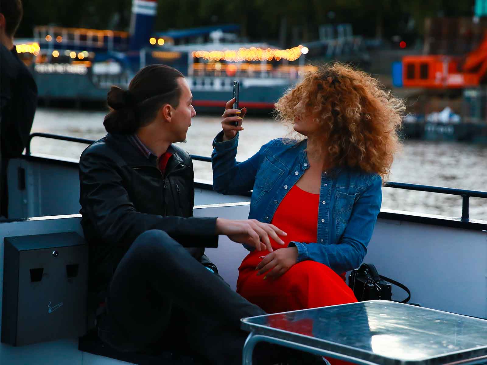 Two students sat on a boat taking pictures