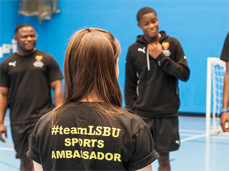 A sports ambassador stood in front of students in the sports hall