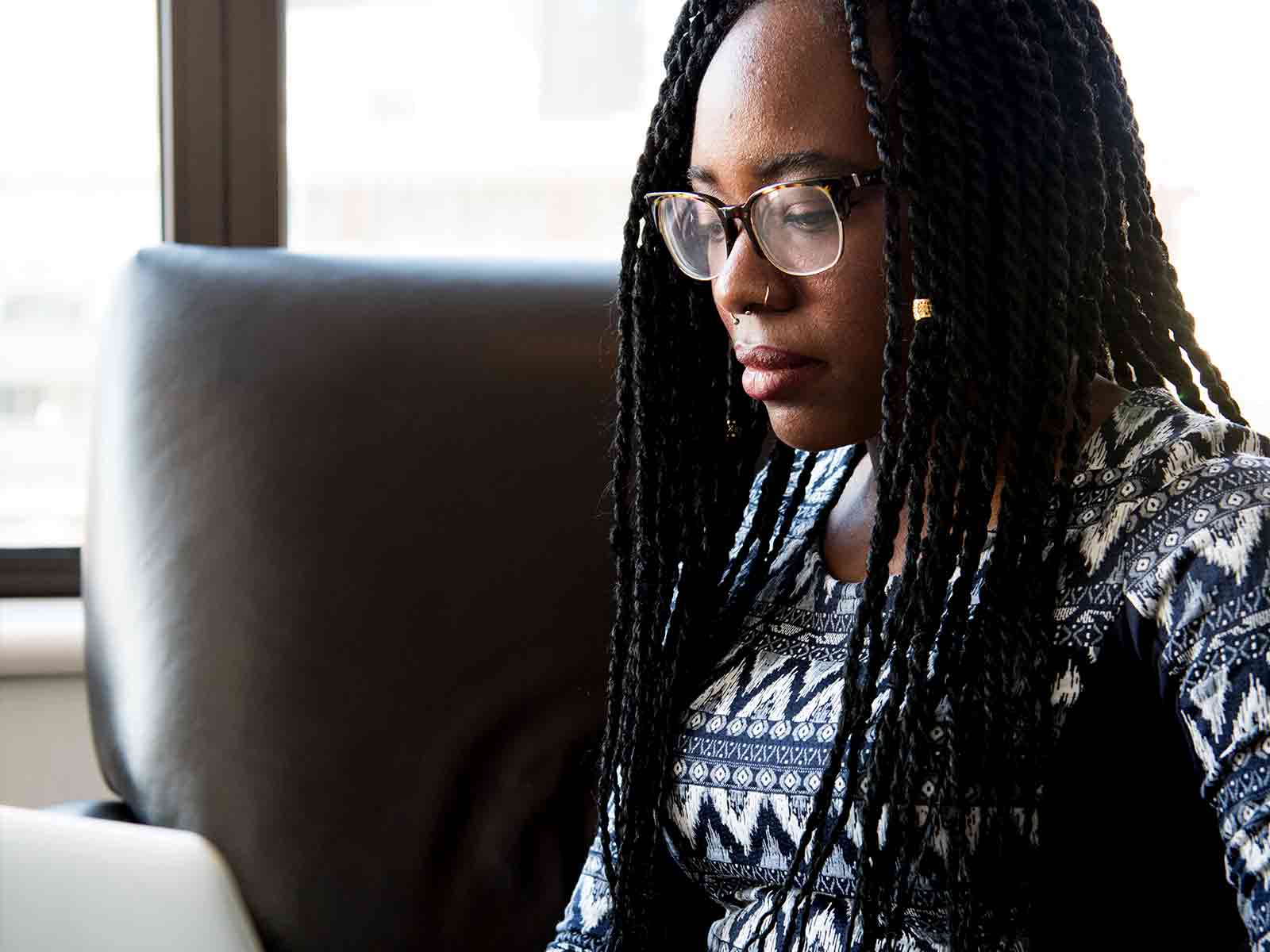 A student sat on a sofa looking at their laptop
