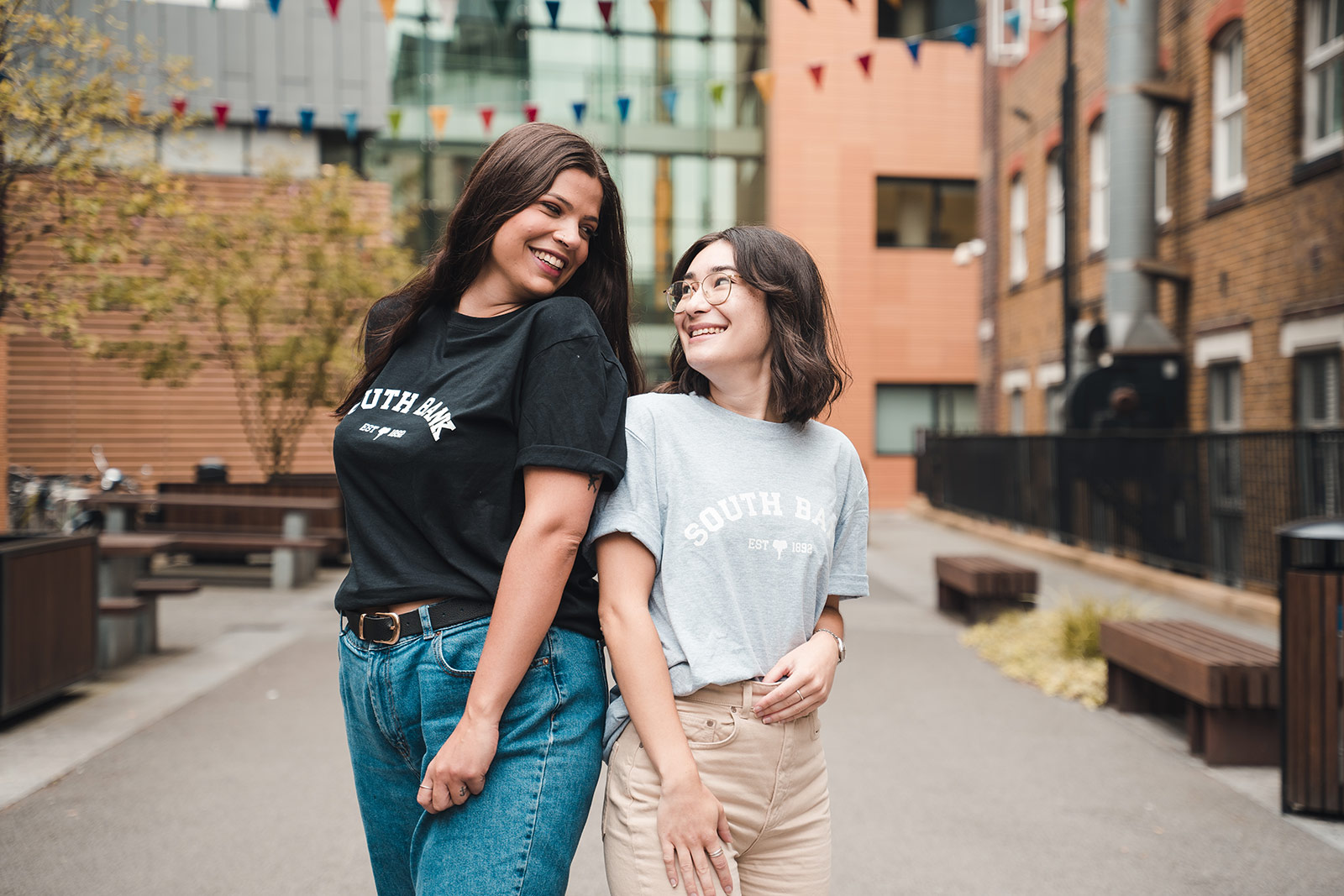 Models wearing Students' Union T-shirts and smiling at each-other