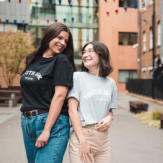 Models wearing Students' Union T-shirts and smiling at each-other